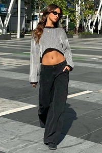 Vue de rue d'un jean cargo ample avec rivets associé à un pull en maille rayé tendance