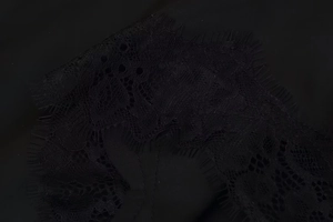 Gros plan sur un tissu en dentelle noire avec détails au crochet et bordure cil