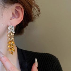 Close-up of elegant wheat leaf drop earrings with gradient marquise-cut crystals on model