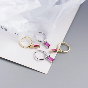 Detailed close-up of S925 silver hoop earrings with rectangular red zircon pendants