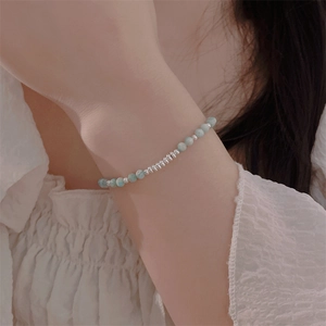 Detailed close-up of natural light blue stone beads and silver pieces bracelet on wrist