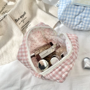 Dettaglio interno della trousse a quadretti trapuntata con fodera a pois e cerniera