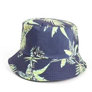 Detailed view of dark blue cotton bucket hat with vibrant yellow pineapple and leaf patterns