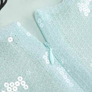 Detalle del vestido de encaje con lentejuelas azul claro y cremallera invisible