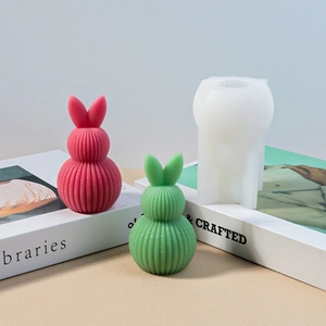 Dettaglio dello stampo in silicone e delle candele a coniglio striate sui libri