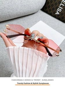 Detail of rimless pink gradient sunglasses featuring golden demon claw metal accents