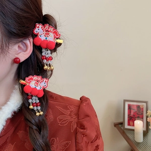 Detailed view of red embroidered horse hairpins with tassels on a female model
