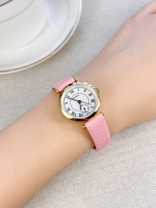 Classic women quartz watch with pink leather strap and Roman numeral dial on wrist