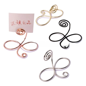 Detailed view of metal wire place card holders in rose gold, gold, silver and black colors