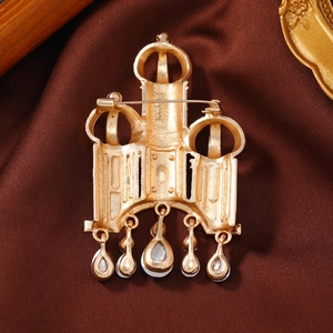 Vintage gold castle brooch with water-drop pendants on dark satin fabric background