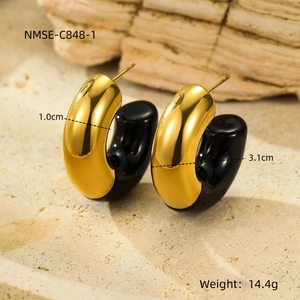 Macro detail of gold C-shaped earrings with black enamel inlay showing dimensions and weight