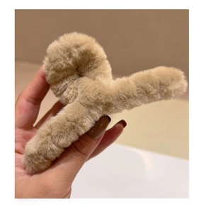 Détail d'une pince à cheveux en peluche douce de couleur marron clair et fausse fourrure