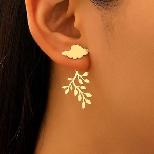 Detail of 3D leaf drop earrings in gold finish worn by a model with metallic shine