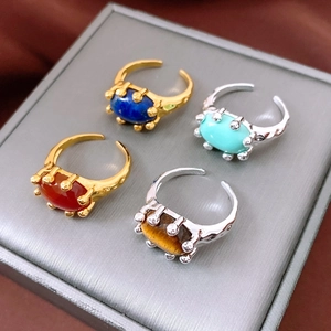 Detailed view of four vintage adjustable rings with oval stones on a jewelry box