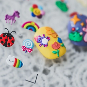 3D embossed nail stickers featuring rainbow, bears and flowers on yellow manicure