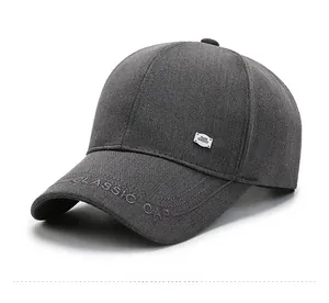 Detail of dark grey baseball cap featuring classic embroidery and a silver metal tag