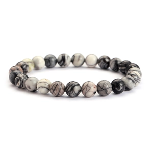 Macro shot of natural marble texture stone beads on a stretch bracelet against white background