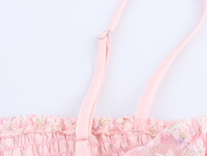 Détail de robe fleurie rose avec boucle en métal réglable et broderie en dentelle fine