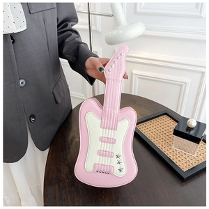 Detailed close-up of a pink guitar-shaped crossbody bag with star rivets and chain strap