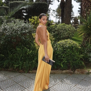 Détail de la robe licou en satin jaune avec dos nu élégant dans un jardin vert