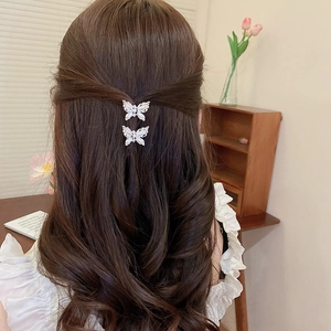 Detail of butterfly hair claw clips with pearls and rhinestones on model's hair