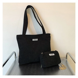 Detail view of black corduroy tote bag and matching mini pouch with Fashion label