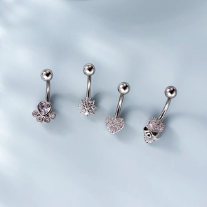 Set of four stainless steel belly rings with heart, flower, and skull motifs in silver