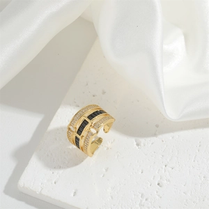 Macro shot of gold wide band ring with black rectangular stone and micro-pave crystals