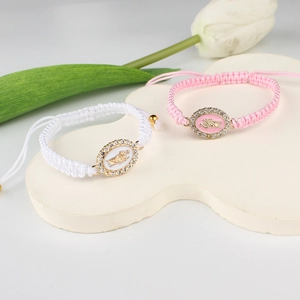 Detail of hand-woven adjustable bracelets with Virgin Mary charm and rhinestone inlay