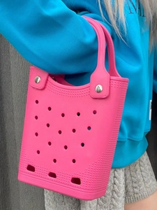 Bright pink EVA beach tote bag with perforated holes shown held by a model