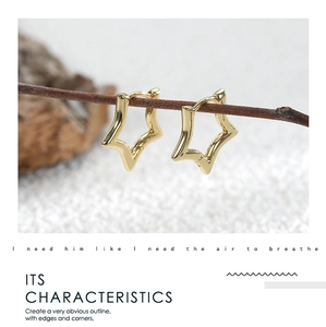 Detailed close-up of shiny gold star-shaped hoop earrings with a polished metal finish