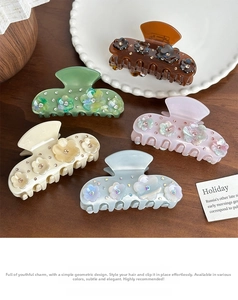 Detailed view of five medium floral acetate hair claws with rhinestones in various colors