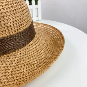 Close-up of natural straw weave and dark brown decorative band on this wide brim beach hat
