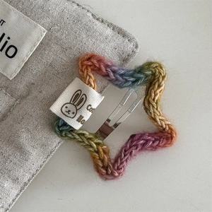 Close-up of rainbow star crochet hair clip with a rabbit label and metal snap pin
