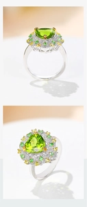 Macro shot of silver ring featuring heart-shaped green peridot and halo gemstones