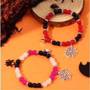Detail view of Halloween spider pendants and colorful beads on magnetic heart bracelets