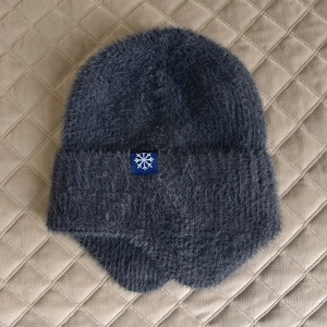 Dettaglio della maglia felpata grigio scuro con patch a fiocco di neve per l'inverno