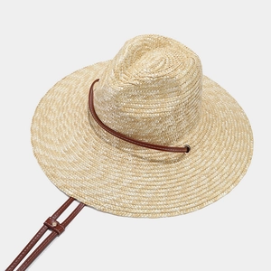 Straw sun hat for women with brown leather cord and wide brim for beach vacation