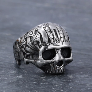 Vintage stainless steel skull ring with gothic engraving on a dark stone background
