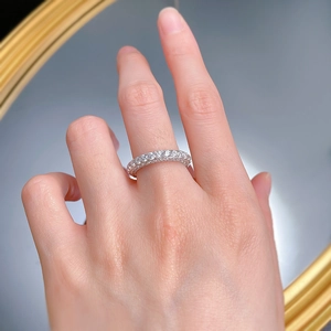 Macro shot of silver eternity ring with pavé diamonds on finger for elegant styling
