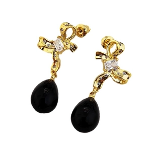 Elegant gold bow earrings with crystal accents and black teardrop pendant on white background