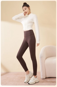 Detailed texture of women's thick thermal yoga leggings and cropped white zip-up knit sweater