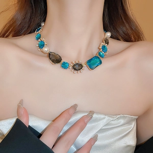 Detail of a vintage-style necklace featuring blue and smoky gemstones with white pearls