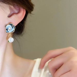 Detail of light blue enamel flower earrings with crystal center and dangling white pearl