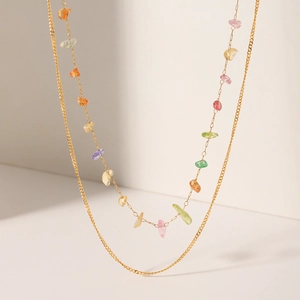 Detail of layered gold necklace featuring colorful crushed stones and delicate chains