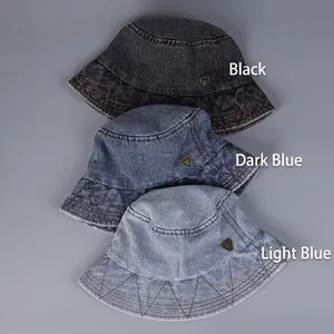 Three denim bucket hats in black, dark and light blue with vintage shield emblems
