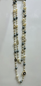 Detail of layered pearl necklace with floral charms and numeric 5 pendant embellishments