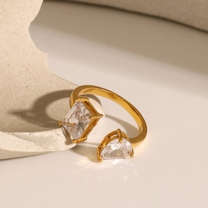 Detailed macro of an 18k gold-plated open ring featuring square and teardrop zircon stones