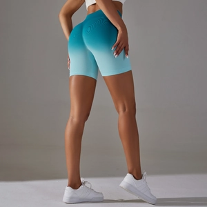 Macro detail of high-waisted seamless peach lift gym shorts with blue gradient knit texture