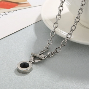 Macro detail of silver chunky chain necklace with OT clasp and black stone pendant